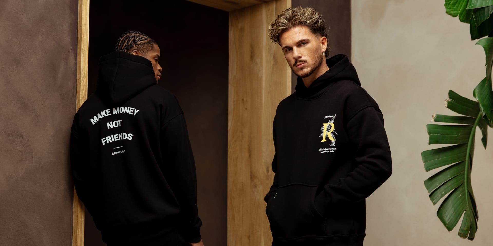 Two black hoodies with a print on the back and a logo on the chest