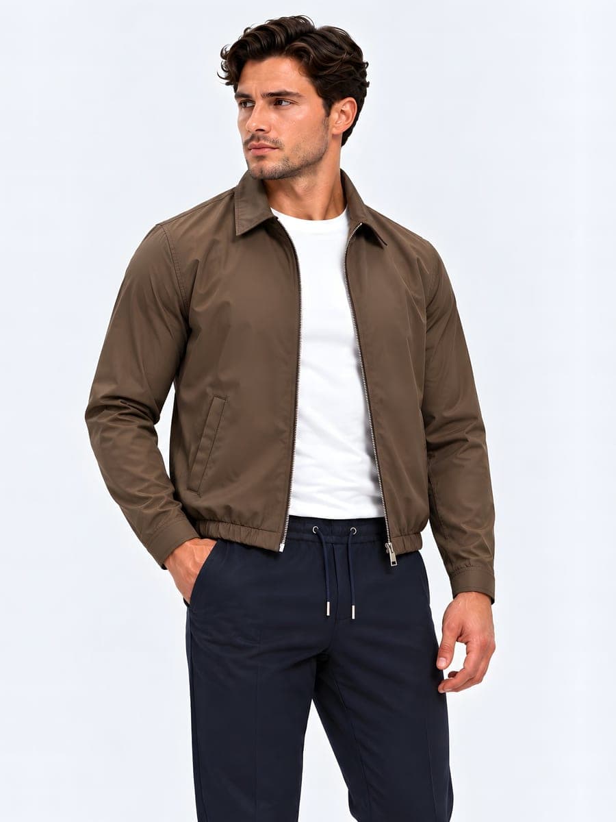 Light jacket with collar and elastic hem in earth brown, worn with a hand in the pocket