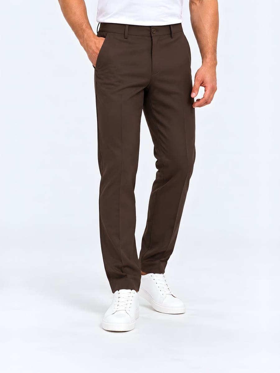 Slim fit trousers with a pressed crease in earth brown, worn with a hand in the pocket