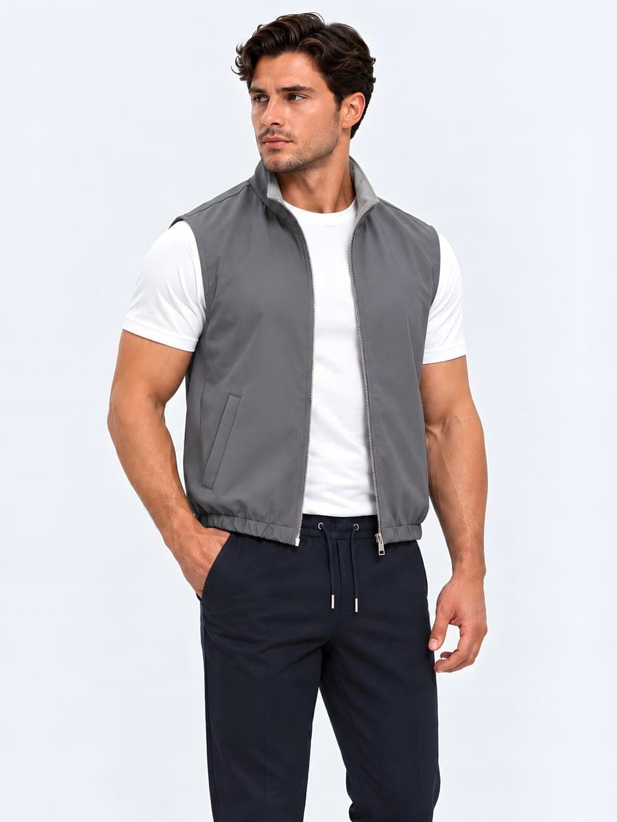 Reversible bodywarmer in anthracite / light grey, worn with a hand in the pocket