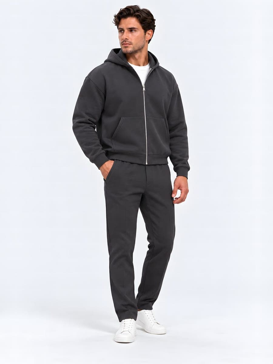 Antraciet oversized zip-hoodie-set, gedragen met een hand in de zak