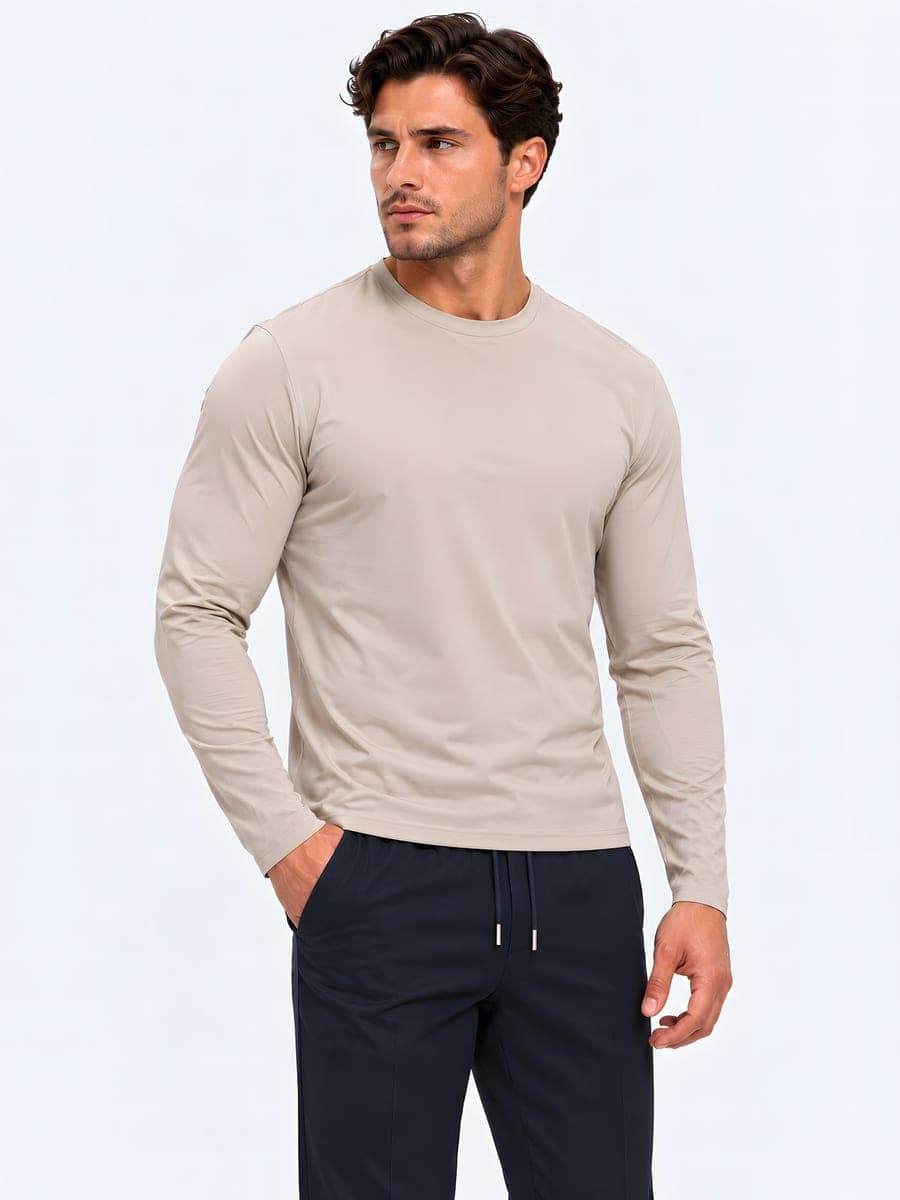 Beige longsleeve met subtiele glans, gedragen met een hand in de zak