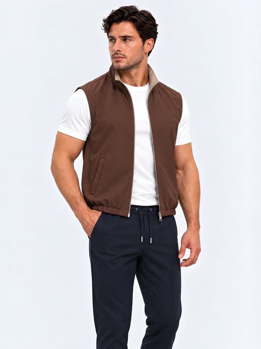 Bruin-beige omkeerbare bodywarmer, gedragen met een hand in de zak