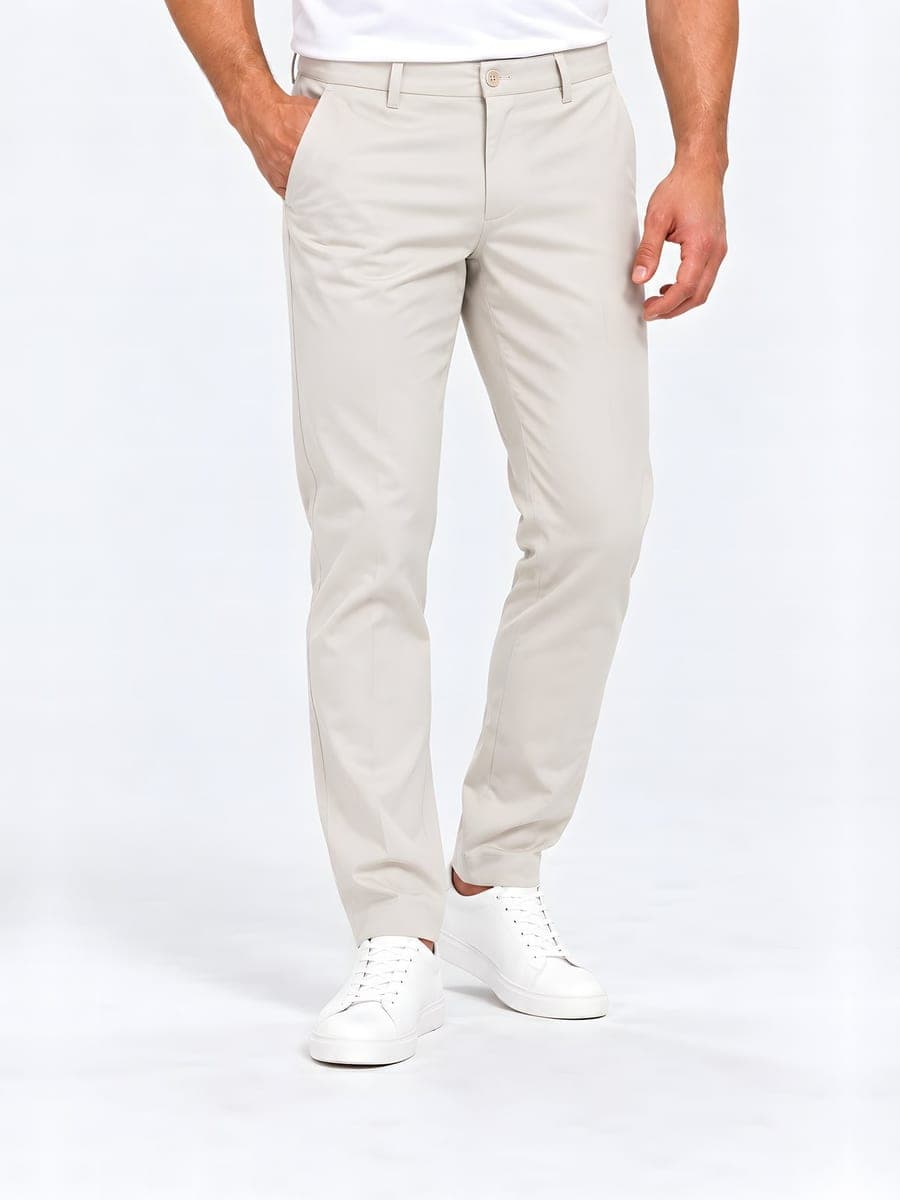 Slim fit trousers with a pressed crease in cream, worn with a hand in the pocket