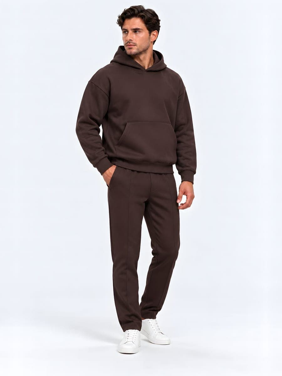 Oversized hoodie set in dark brown, worn with a hand in the pocket