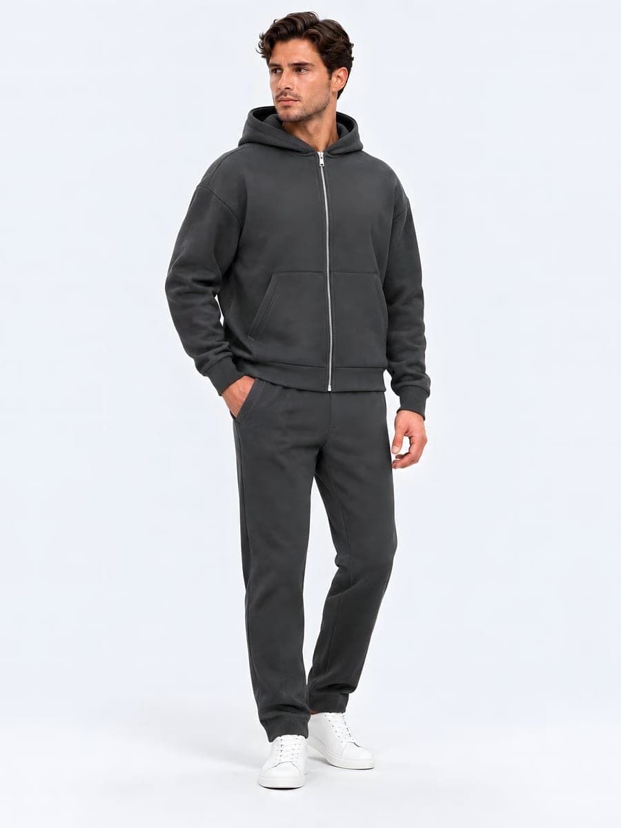 Donkergrijze oversized zip-hoodie-set, gedragen met een hand in de zak