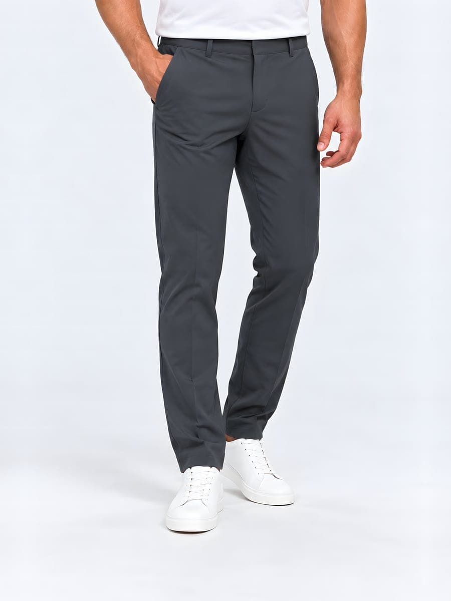 Tapered trousers, matte in dark grey, worn with a hand in the pocket