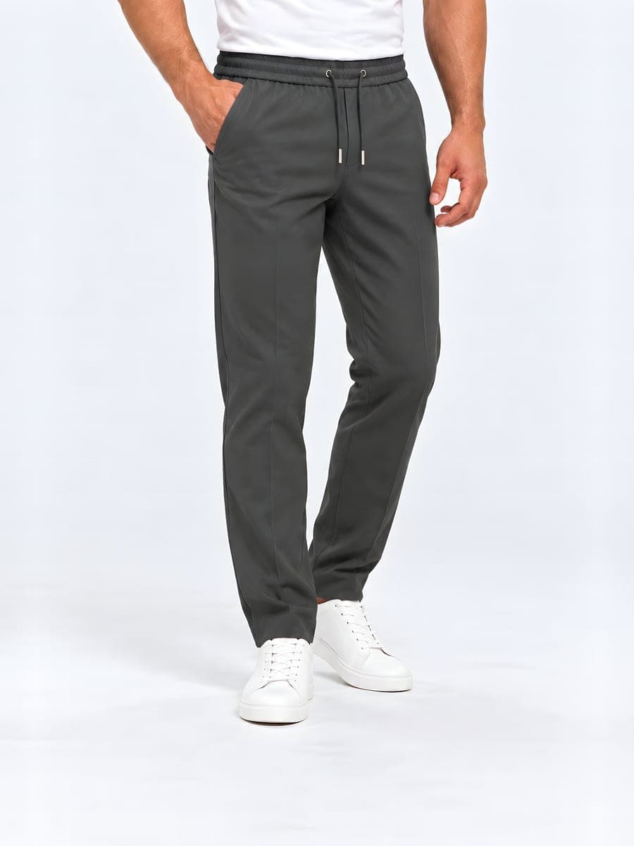 Grijze polyester broek met trekkoord en rechte pijp, gedragen met een hand in de zak