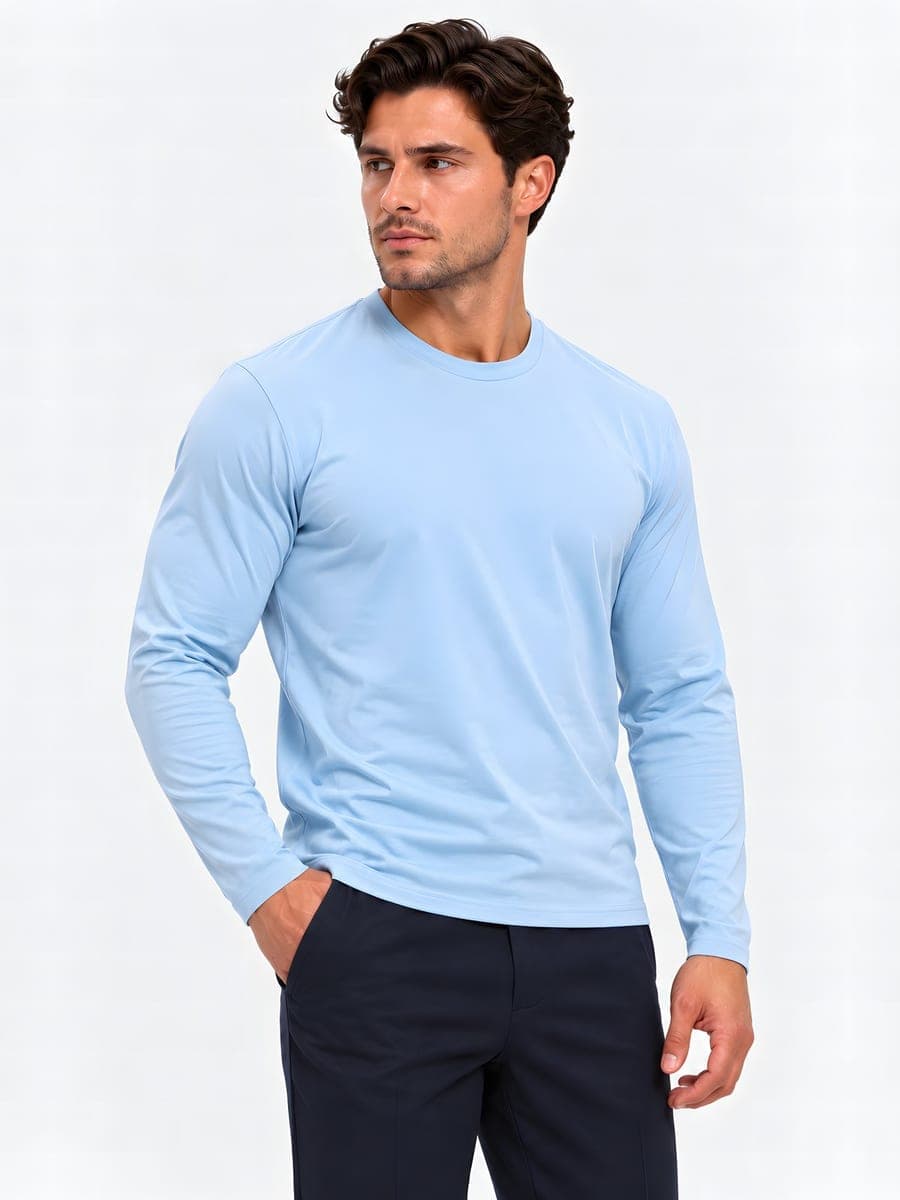 Lichtblauwe longsleeve met subtiele glans, gedragen met een hand in de zak