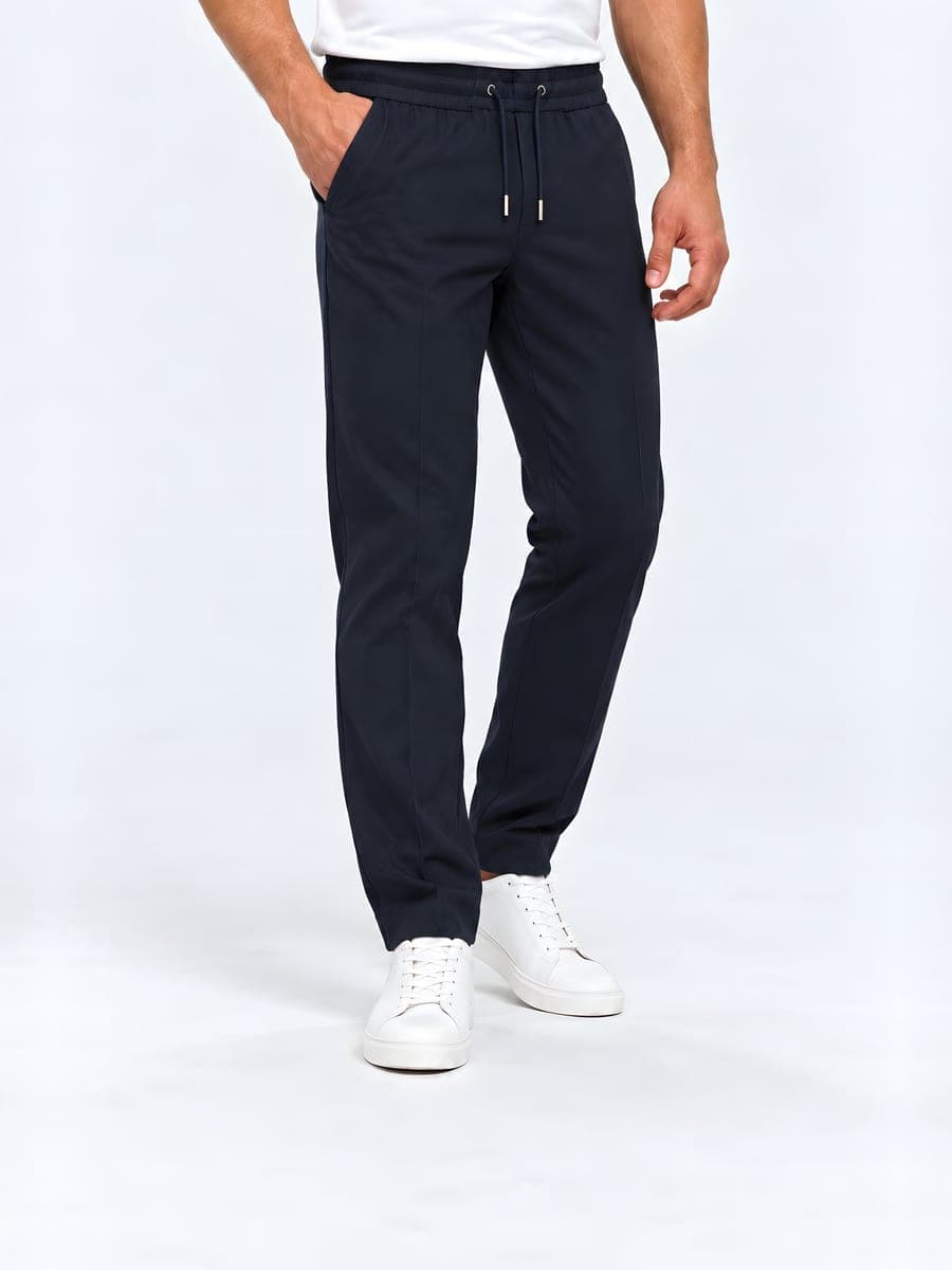 Navy polyester broek met trekkoord en rechte pijp, gedragen met een hand in de zak