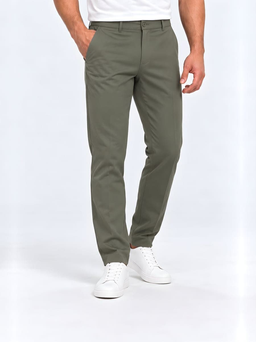 Slim fit trousers with a pressed crease in olive green, worn with a hand in the pocket
