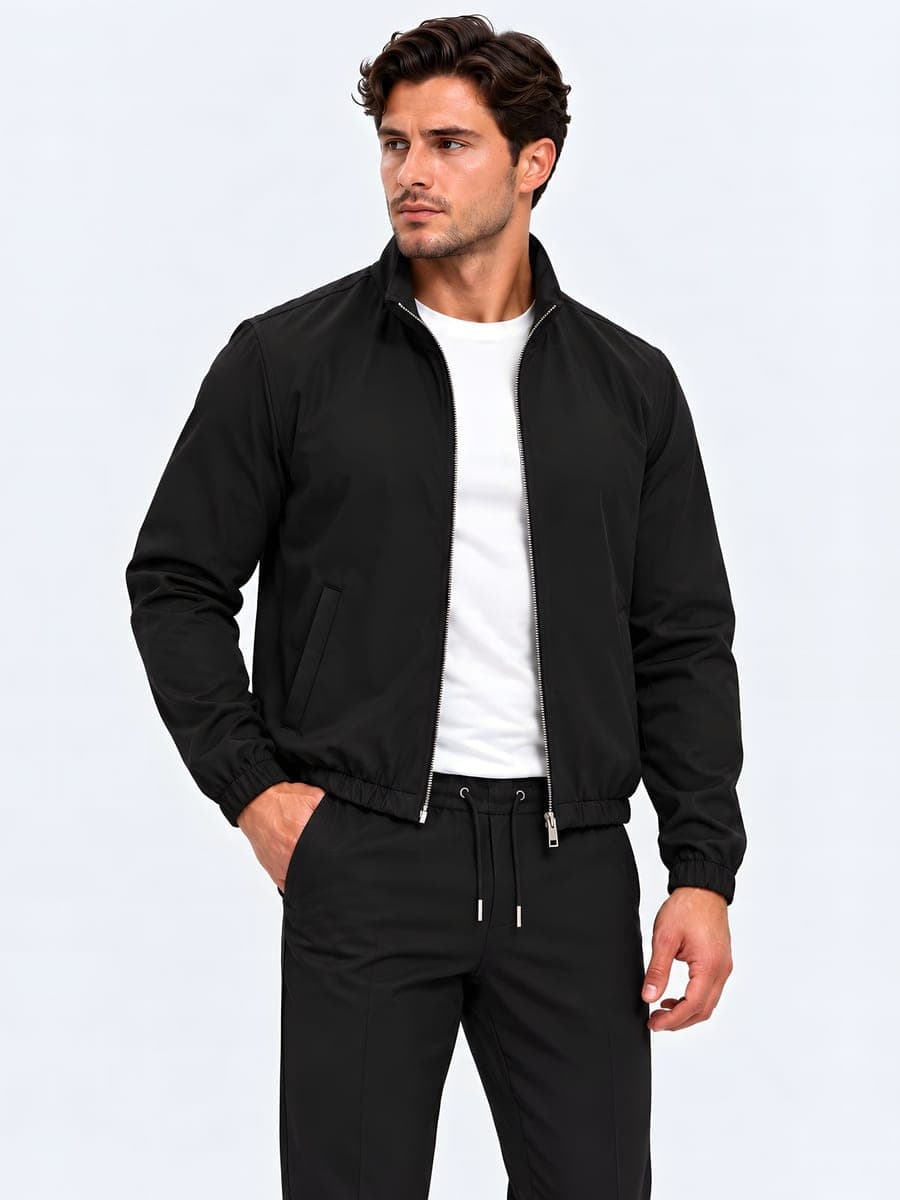 Zwart polyester jack met tweewegrits, gedragen met een hand in de zak