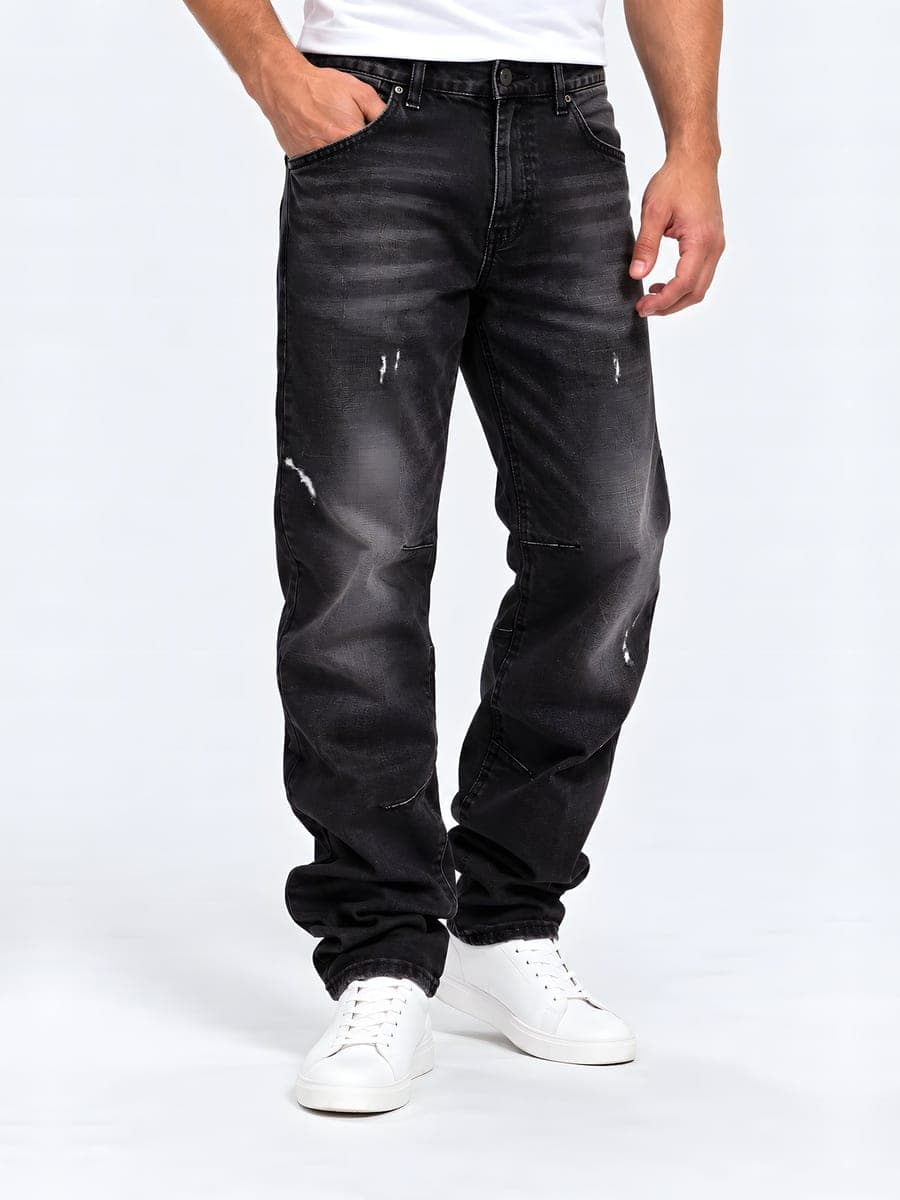 Zwarte baggy jeans met wassing, gedragen met een hand in de zak