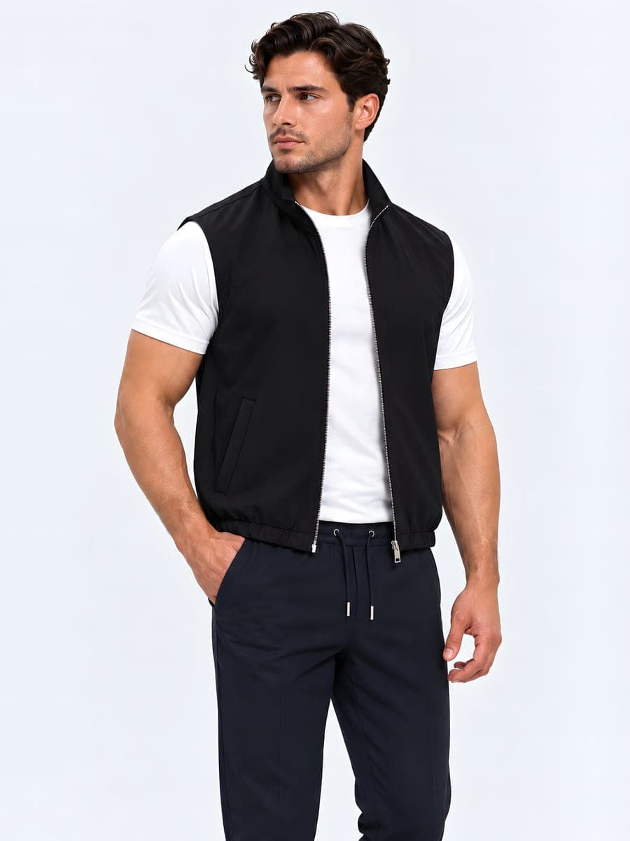 Zwarte omkeerbare bodywarmer, gedragen met een hand in de zak