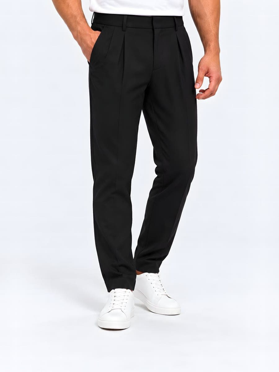 Zwarte pantalon met bandplooien, gedragen met een hand in de zak