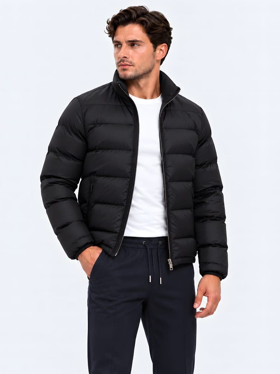 Zwarte winterjas met afneembare capuchon, gedragen met een hand in de zak