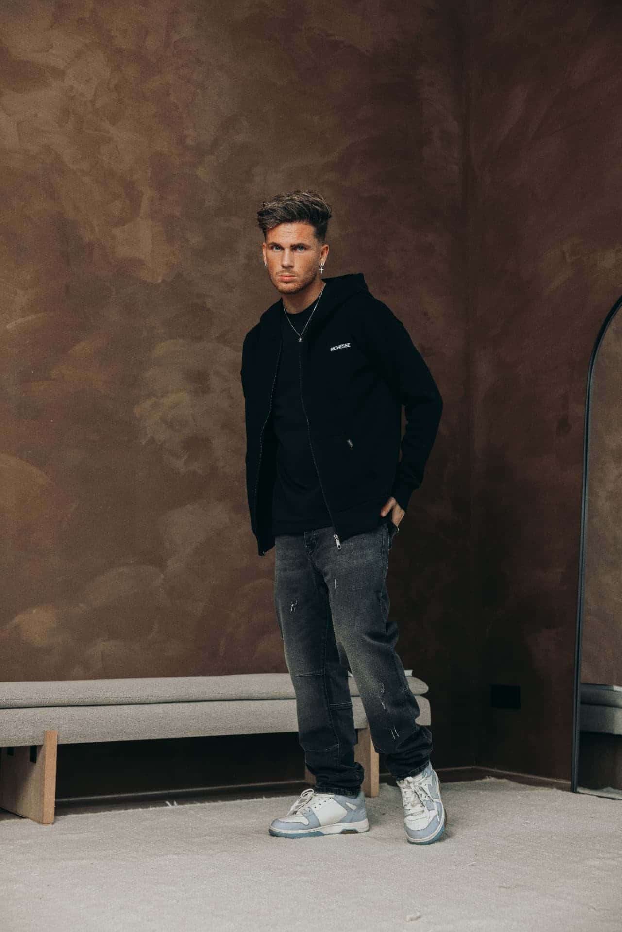 Black zip hoodie with a logo on the chest